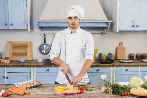 Chef cuisinier qui prépare un repas au domicile de ses clients